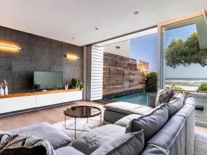 a living room with a couch and a tv at Beachfront Bliss in Cape Town