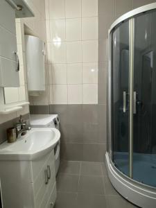 a white bathroom with a sink and a shower at Lake City Apartment in Struga