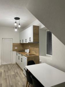 a kitchen with white cabinets and a table with chairs at Lake City Apartment in Struga