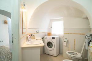 une salle de bain avec un lavabo et une machine à laver dans l'établissement Trullo Tre Coni, à Cisternino