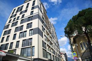 Un edificio alto y blanco al costado de una calle. en Tirana LUX Apartments, en Tirana