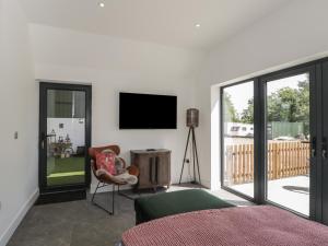 a bedroom with a bed and a television on the wall at The Hay Barn in Gloucester