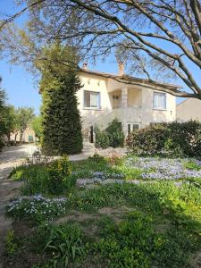 a large house with a garden in front of it at Partie de villa in Velleron