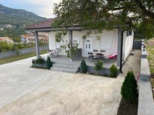 a white house with a table and chairs on a porch at Eco lodge apartment in Bar