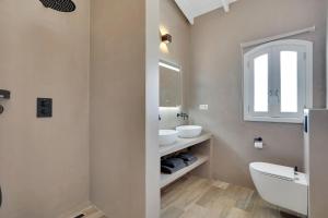 ein Badezimmer mit Waschbecken und Toilette und einem Fenster in der Unterkunft Oceanfront villa Casa Mar Azul in Kralendijk