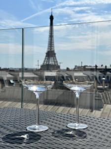 due bicchieri di vino appoggiati su un tavolo con la torre Eiffel di Pépite Tour Eiffel a Parigi