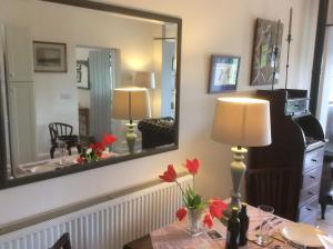 a dining room with a table with a mirror at The Old Coach House in Bungay
