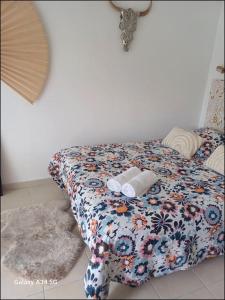 a bed with a floral bedspread and two towels on it at Studio mi casa es su casa in Vauvert +31 photos