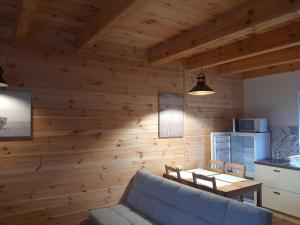 a living room with wooden walls and a blue couch at Osada Szwedzka Domek Plus in Rusinowo