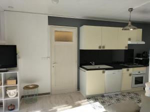a kitchen with white cabinets and a white door at Appartement au Calme in Saint-Cézaire-sur-Siagne