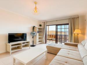 a living room with a couch and a tv at Seaside apartment with a sea view in Costa Del Silencio