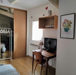 a room with a desk with a television and a bedroom at Gîte en Provence in Entraigues-sur-la-Sorgue
