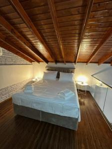 a large bed in a room with a wooden ceiling at Stenakas Apartments in Chios