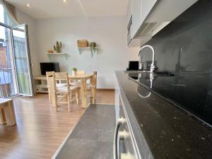 a kitchen with a black counter top and a table at Loft Pere IV in Barcelona