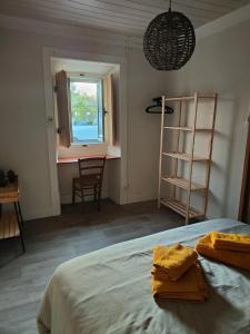 a bedroom with a bed and a window and a chair at Como EM Casa in Alburitel