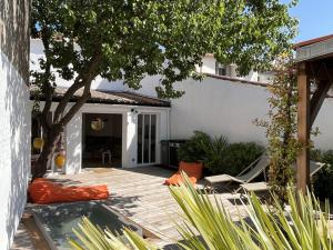 a patio with a tree and a house at Maison Rénovée avec Jacuzzi et Cuisine d'Été au Centre du Village - FR-1-434-97 in La Couarde-sur-Mer