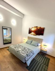 a bedroom with a bed and a painting on the wall at Ático Playa Foz con Terraza in Foz