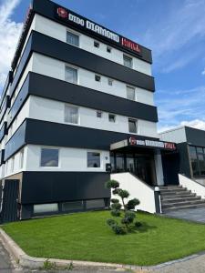 a black and white building with a tree in front of it at DiDo Diamond Hotel in Dietzenbach