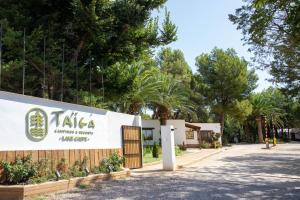 a sign for a building with trees in the background at TAIGA Lake Caspe in Caspe