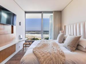 a bedroom with a large bed with a view of the ocean at Beachfront Bliss in Cape Town