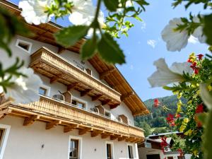 budynek z drewnianymi balkonami i kwiatami w obiekcie Boutique Hotel Pinzgauerhof w Kaprunie