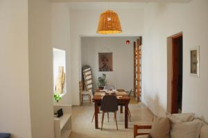 a dining room and living room with a table and chairs at Villa FLORA in Kattavía