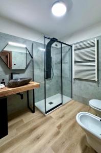a bathroom with a glass shower and a sink at CozySuite Pinzolo centro New boutique apartment in Pinzolo +10 photos