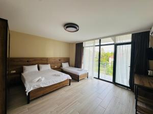 a bedroom with two beds and a large window at Paradise Shekvetili in Shekhvetili