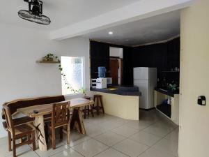 a kitchen with a table and chairs and a refrigerator at BRISAMAR GUESTHOUSE in Puerto Escondido