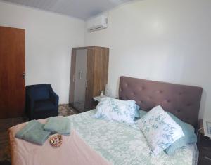a bedroom with a bed with blue and white pillows at Studio Marangoni Hospedagem in Treze Tílias
