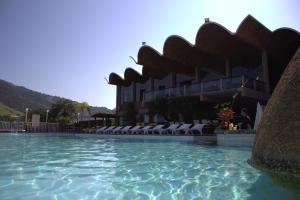 a resort with a swimming pool and a building at Portogalo Suite Hotel in Angra dos Reis