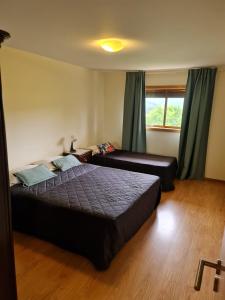 Un dormitorio con dos camas y una ventana. en Apartamentos Do Ermal, en Vila Boa 54 fotos más