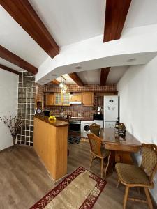 a kitchen with a table and chairs in a room at Casa cu brazi in Porumbacu de Sus