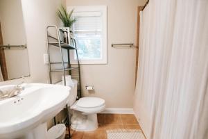 a bathroom with a sink and a toilet and a window at Cozy Cottage - Walk To Campus, Stadium, Downtown in Athens +41 photos
