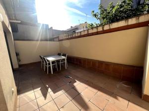 eine Terrasse mit Tisch und Stühlen auf einem Balkon in der Unterkunft Apartamento entero con patio en Terrassa, Barcelona in Terrassa