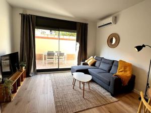 ein Wohnzimmer mit einem blauen Sofa und einem Tisch in der Unterkunft Apartamento entero con patio en Terrassa, Barcelona in Terrassa