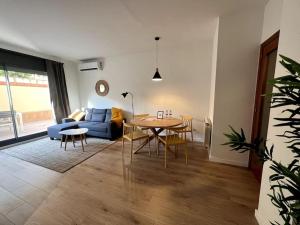 ein Wohnzimmer mit einem blauen Sofa und einem Tisch in der Unterkunft Apartamento entero con patio en Terrassa, Barcelona in Terrassa