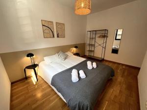 ein Schlafzimmer mit einem Bett mit weißen Hausschuhen darauf in der Unterkunft Apartamento entero con patio en Terrassa, Barcelona in Terrassa