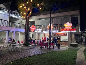 Eine Gruppe von Menschen sitzt nachts vor einem Restaurant. in der Unterkunft Mr3 Inn in Camalaniugan
