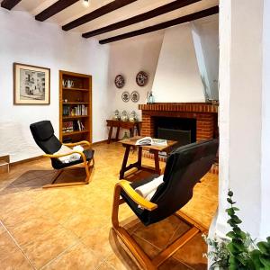 a living room with two chairs and a fireplace at La Caseta de Rotova - Casa Rural para desconectar in Rótova