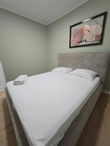 a large white bed in a bedroom with a picture on the wall at GK apartments Ballerina in Bat Yam +23 photos