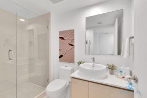 Un baño con inodoro, lavabo y ducha. en Infinite View Balcony Pool Near Beach, en Hallandale Beach
