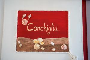 a red cake with shells on it with the word congratulations at La casa del pescatore in Oliveri