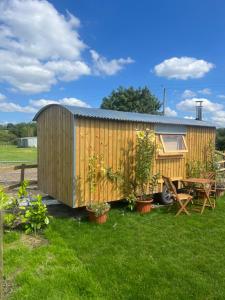 a tiny house in a yard with a table at Poachers Keep, Shepherds Hut in Endon