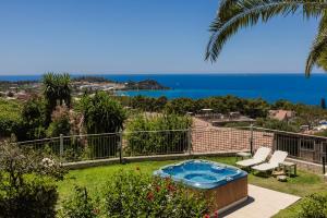 a garden with a hot tub and a view of the ocean at Irilena Studios and Apartments in Lassi