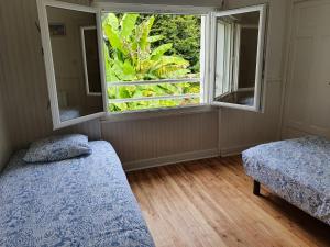 a bedroom with two beds and a large window at Jardin clos et calme, vélos à disposition, plages à 2 kms in Tréffiagat +25 photos