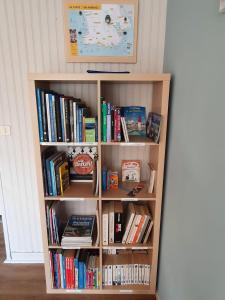 a book shelf full of books in a room at Jardin clos et calme, vélos à disposition, plages à 2 kms in Tréffiagat