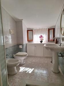 a bathroom with two sinks and a toilet and a window at Apposentu Sant'Antioco in SantʼAntìoco +38 photos