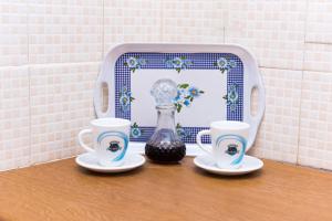 a table with two cups and a vase and two cups at Kottas Apartments in Paralia Vrachou