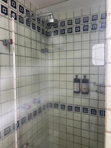 ein Badezimmer mit einer Dusche mit blauen und weißen Fliesen in der Unterkunft Flat exclusivo vista mar in Recife